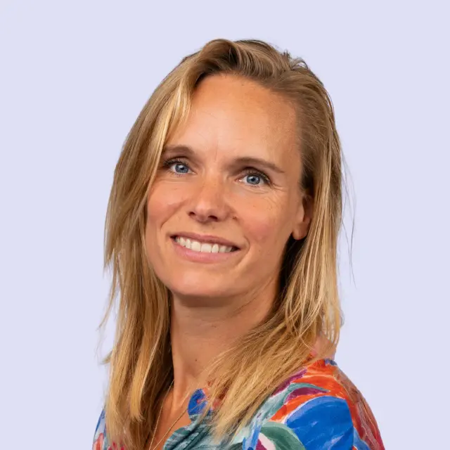 Portret van Lyke Poortvliet tegen een lichtblauwe achtergrond.