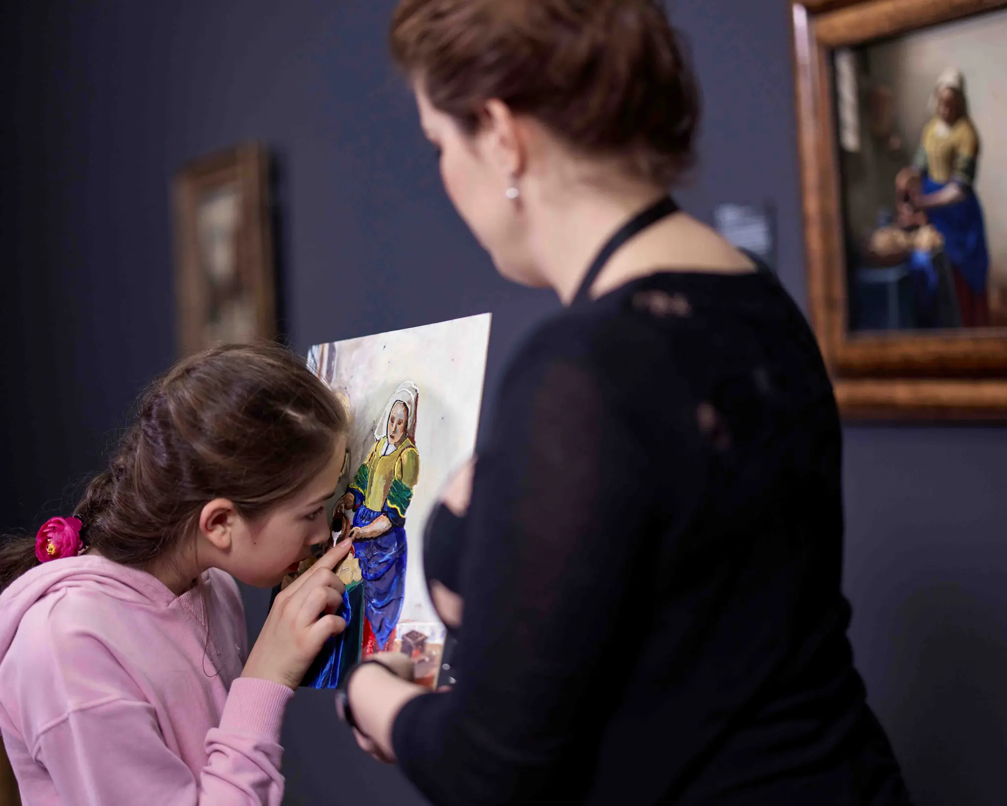 Een meisje voelt met haar vingers een reliëfafdruk van het schilderij 'Het Melkmeisje' van Johannes Vermeer.
