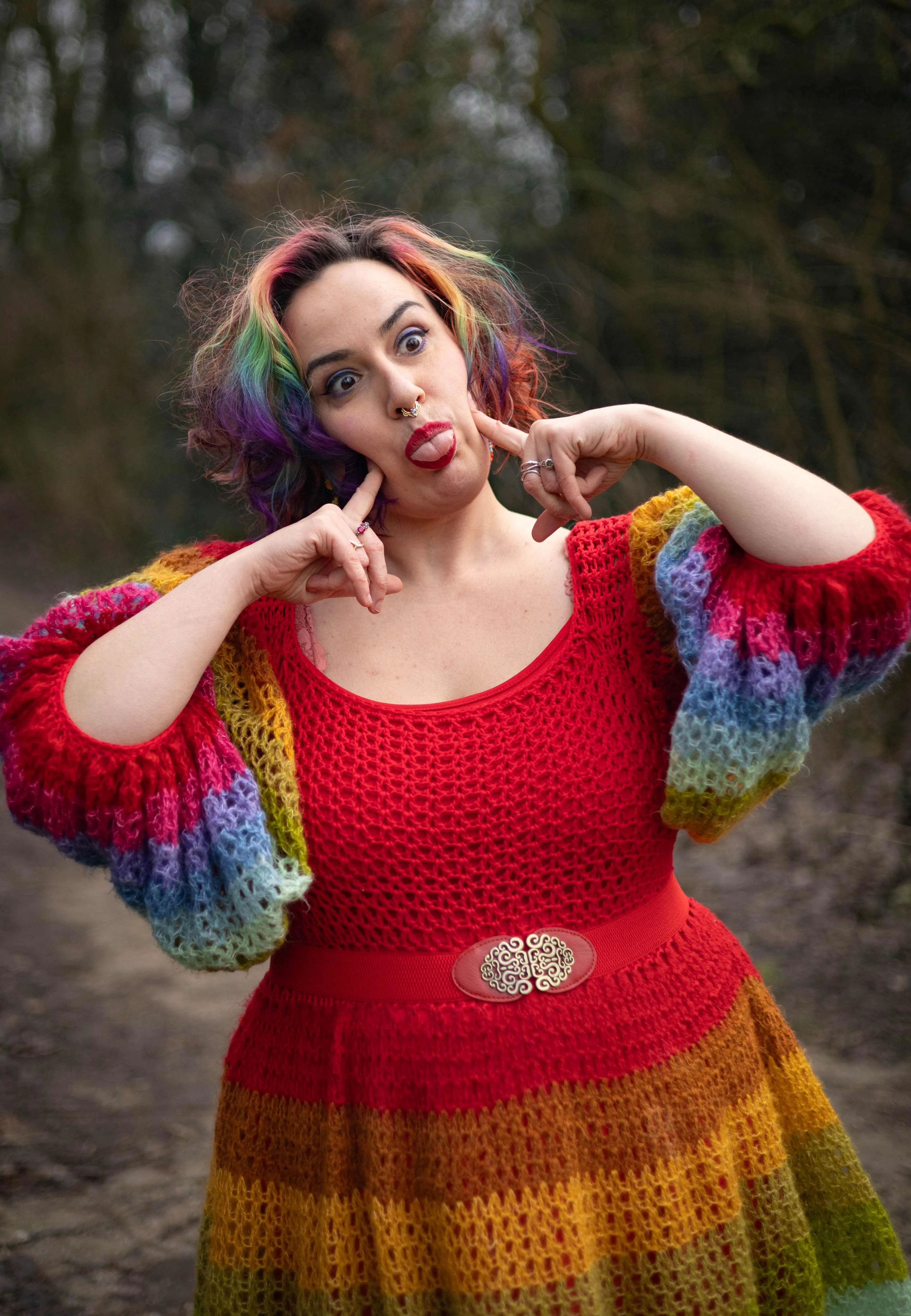 Jopie Louwe Kooijmans steekt diens tong uit en drukt met diens wijsvingers op diens wangen.